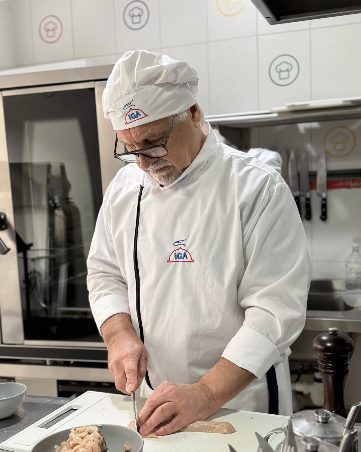 Cocinero cortando pechugas de pollo sobre una tabla