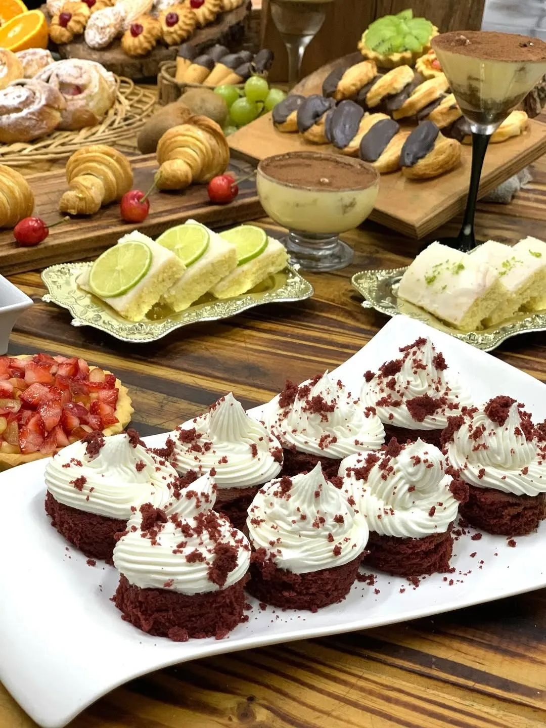 Cupcakes de red velvet y bocados dulces en mesa de producción