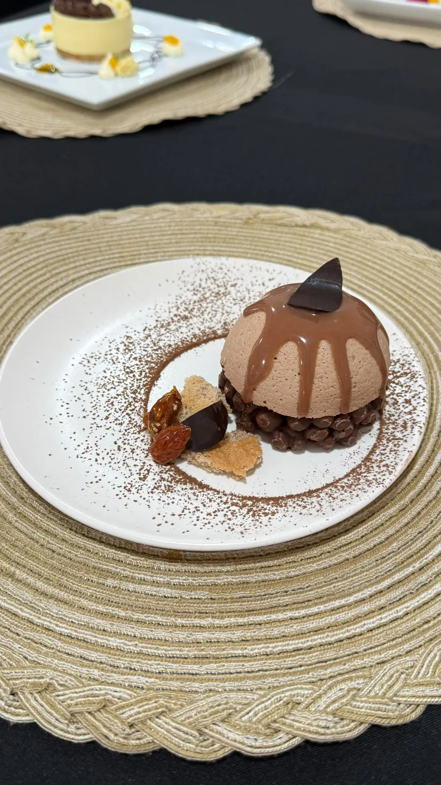 Postre de chocolate emplatado con crocante y polvo de cacao