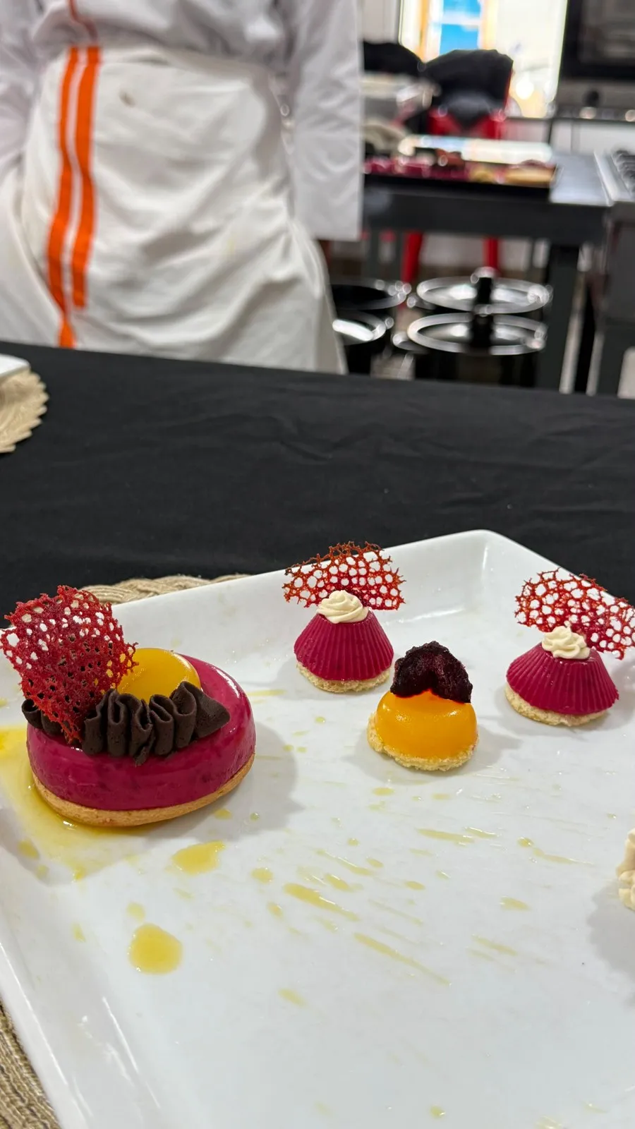 Postres de frutos rojos emplatados sobre mantel negro