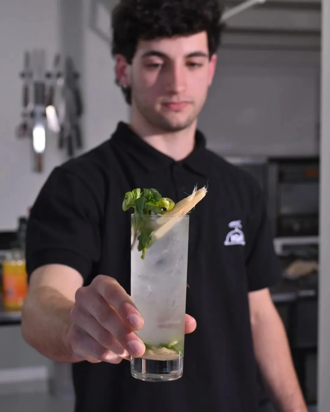 Alumno con remera de IGA sirviendo un trago con hielo