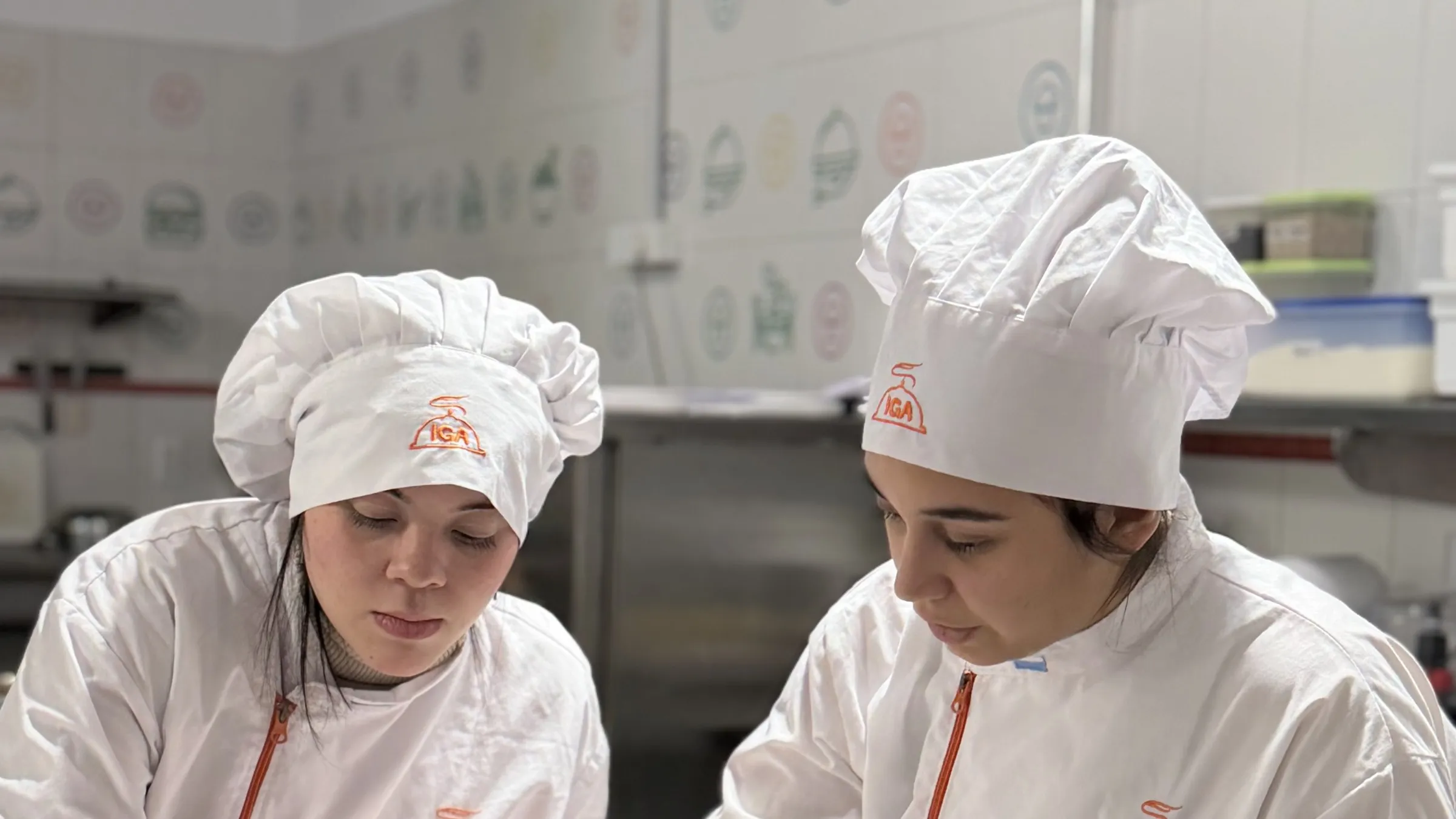 Dos alumnas con cofia de IGA trabajando en la mesada